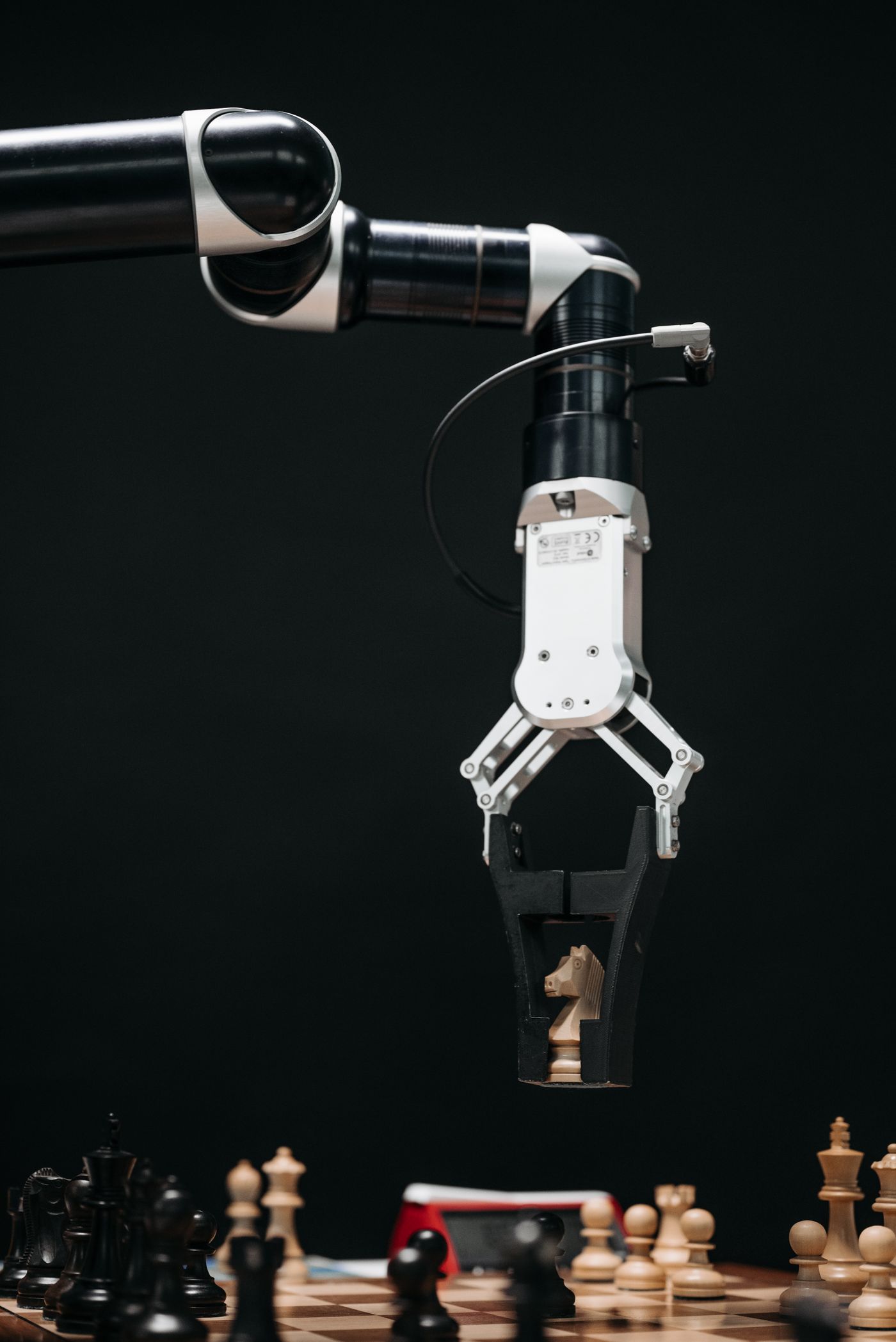 Un bras robotisé déplace un cavalier sur un échiquier
